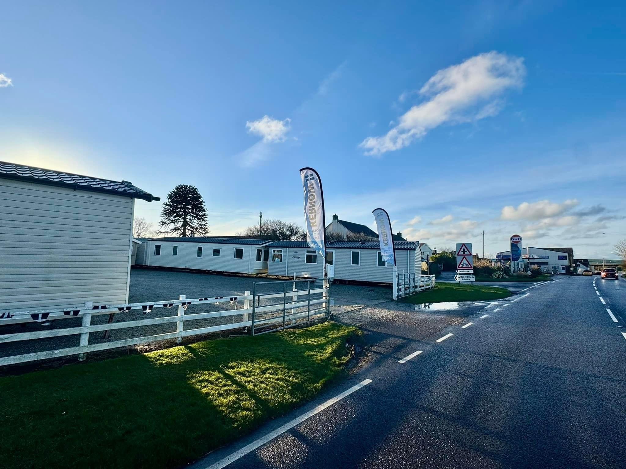 The Kernow showground entrance on the A39 at Wainhouse Corner, with static caravans and Kernow flags visible from the road